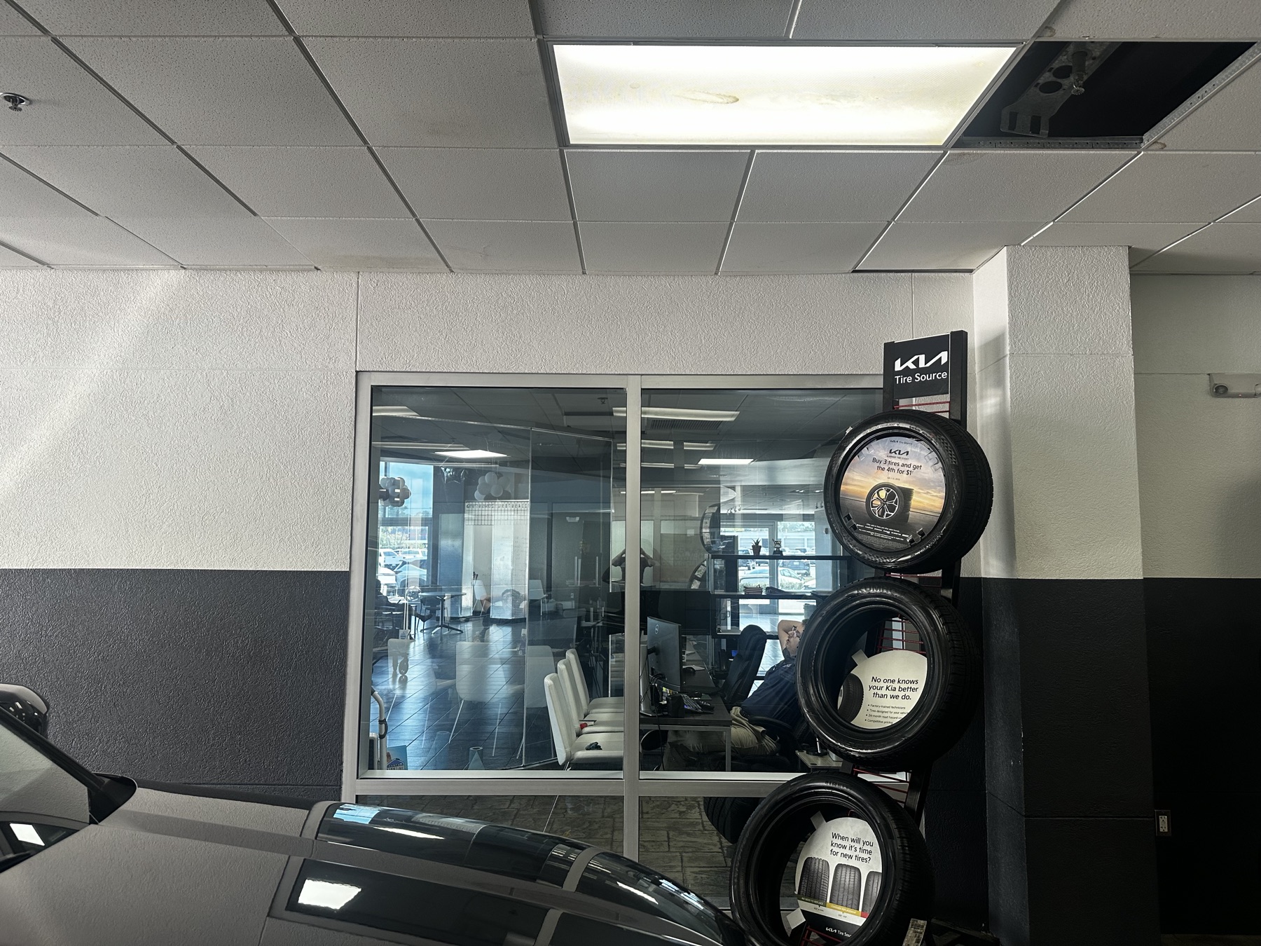 Untinted office window at a dealership, interior clearly visible from the service bay